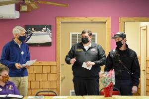 Bob Bindschadler of the Quilcene-Brinnon Garden Club, standing at left, and club president Ruth Dunham, seated, presented a $500 check to Brinnon Fire & Rescue chief Tim Manly, second from right, and Quilcene Fire & Rescue Lt. Nick Singleton last Thursday. Manly will use the funding to buy Guardian Angel LED safety lights for rural first responders to wear. Diane Urbani de la Paz/Peninsula Daily News