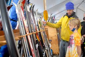 Ned Hammar of Port Angeles and his son, Felix Lubinski Hammar, 9, examine a rack of snow skies during Saturdays Winterfest ski swap in the Black Ball Ferry parking lot on the Port Angeles waterfront. The event, a fundraiser for the Hurricane Ridge Winter Sports Club, featured a variety of skis, snowboards and related sports gear. No total from the event was available on Sunday. (Keith Thorpe/Peninsula Daily News)