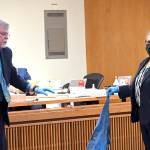 State Patrol Forensic Analyst Johan Schoeman, left, and Michele Devlin, deputy prosecuting attorney, on Monday show the jury in Dennis Bauers murder trial the tarp that was wrapped around the body of victim Darrell Iverson. (Paul Gottlieb/Peninsula Daily News)