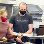 Volunteer Laura Street and her husband Matt Patterson of Gardiner were on the kitchen crew Thursday as the Tri-Area Community Center served hundreds of takeout meals. (Diane Urbani de la Paz/Peninsula Daily News)