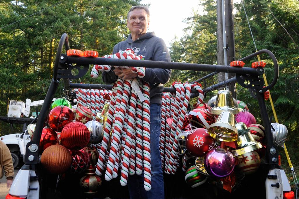 <strong>Matthew Nash</strong>/Olympic Peninsula News Group
Craig Tenhoff prepares to hand off candy canes to place along Diamond Point Road earlier this month as the road was transformed into Holiday Lane. Each year since 2007, residents have lined the road with Christmas decorations for nearly 4 miles starting from the roads intersection at U.S. Highway 101. About 35 volunteers helped hang ornaments, candy canes and banners.