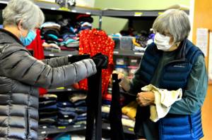 Volunteers A.J. Laverty, left, and Marsha Hamacher organize the winter outfits at the Community United Methodist Churchs clothing room. The room is open for free shopping on Saturdays. (Diane Urbani de la Paz/Peninsula Daily News)