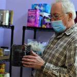 Pastor Scott Rosekrans of the Community United Methodist Church shows off one of the tiny stoves made by volunteer Jean Holtz. People without access to a kitchen can use the camp stoves to heat meals from the churchs food pantry. (Diane Urbani de la Paz/Peninsula Daily News)