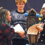 Gretta Thorson, right, presents an SHS student with a skateboard as part of the Sequim High School Winter Wishes assembly in December 2019 in this Olympic Peninsula News Group file photograph.