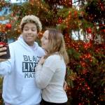 Julyan Hardeman and Sebrena Merly, both of Longview, take a selfie in front of the Christmas tree at the Conrad Dyar Memorial Fountain in downtown Port Angeles on Wednesday. The tree, adorned with about 10,000 miniature lights and several dozen ornaments added later, will oversee the downtown area through the holidays. (Keith Thorpe/Peninsula Daily News)