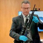 Detective Sgt. Eric Munger of the Clallam County Sheriffs Office prepares to show a semi-automatic rifle presented in the triple-murder trial of Dennis Marvin Bauer. (Paul Gottlieb/Peninsula Daily News)