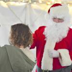 Dashiell Lemay, 4, supported by mom Amy Lemay of Port Townsend, fist-bumped with Santa Claus under the Tyler Street Plaza tent in Port Townsend on Saturday afternoon during the Port Townsend Main Street's seasonal activities that included a tree-lighting at dusk.   Diane Urbani de la Paz/Peninsula Daily News