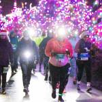 Sylvia Snell of Bremerton, No. 204, leads a pack of 5K and 10K runners in the rain to the finish line in Blyn at the Jamestown SKlallam Glow run Saturday night. Snell ran in the 5K, along with Julie Dunlap, No. 201, at left. Kimberly DaArton, No. 500, ran in the 10K. (Run the Peninsula)