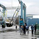 Members of the Marvin Shields Ship 1212 of the Sea Scouts watch as the sailboat Aurora is carried to the Platypus Marine Inc. shipyard for bottomside maintenance and inspection on Wednesday in Port Angeles. The boat, which was donated to the Seas Scouts by Arvo and Christiane Johnson, was hauled out by Platypus, which is donating much of the work, a total of about $5,000, the company said. Sea Scouts is a co-educational branch of the Boy Scouts of America that promotes boating skills and water safety for youths ages 14 to 20. (Keith Thorpe/Peninsula Daily News)