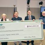 Holding a giant check of the $540,000 donation from the Olympic Medical Center Foundation to the hospital are, from left, OMC Executive Committee member Karen Rogers, OMC Commissioner Chair John Nutter, OMC CEO Darryl Wolfe, and Bruce Skinner, executive director of the foundation. (Dave Logan/For Peninsula Daily News)