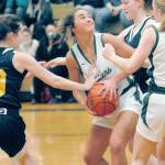Port Angeles Eve Burke, center, looks for the hoop while defended by Bainbridges Caroline Payne, left, and Macy Kingrey on Thursday in Port Angeles. (Keith Thorpe/Peninsula Daily News)