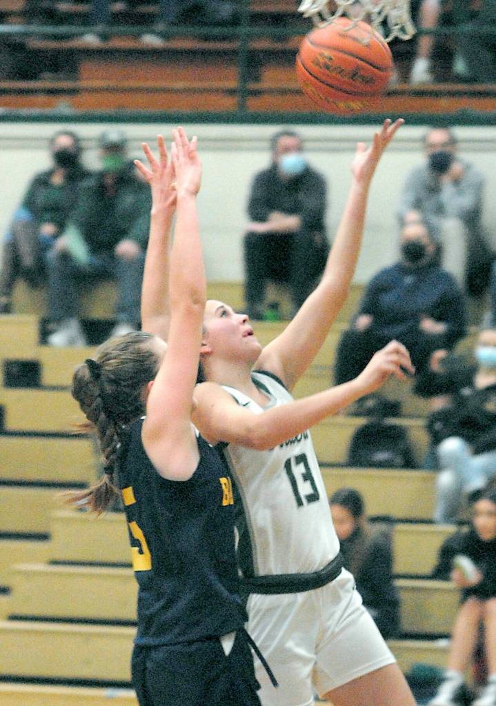 Port Angeles Bailee Larson, right, takes an easy layup as Bainbridges Isabella Ramirez defends the lane on Thursday at Port Angeles High School. (Keith Thorpe/Peninsula Daily News)