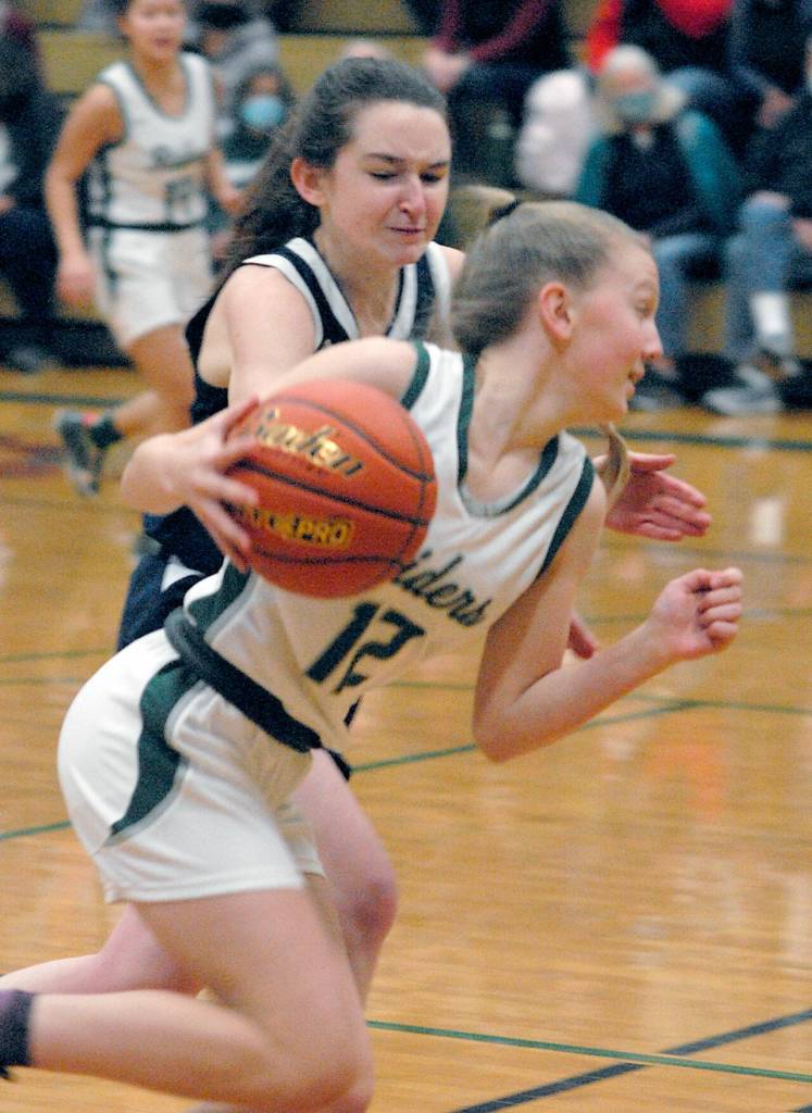Port Angeles Isabelle Felton, front, spins towards the lane as Bainbridges Caroline Payne on Thursday night in Port Angeles. (Keith Thorpe/Peninsula Daily News)