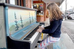 Keith Thorpe/Peninsula Daily News
Marion Mittell, 10, of Seattle takes time off during a visit to the Olympic Peninsula to play an outdoor piano in the 100 block of East First Street in downtown Port Angeles on Wednesday. The piano, placed on the sidewalk as a public music installation by the owner of the nearby First Street Haven restaurabnt, has been available seasonally to passers-by since 2017.