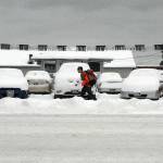 A pedestrian walks past a line of snow-covered vehicles on the lot of Randys Auto Sales in the 800 block of East First Street in Port Angeles on Tuesday. A small amount of overnight snow added to previous snowfalls that began on Christmas Day along most of the North Olympic Peninsula. (Keith Thorpe/Peninsula Daily News)