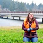 Sarah Doyle, the North Olympic Salmon Coalitions program and partnership manager, demonstrates the planting of a tree near the Kilisut Harbor bridge between Marrowstone and Indian islands. (Diane Urbani de la Paz/Peninsula Daily News)