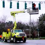 A state Department of Transportation crew fixes a wind-damaged stoplight on Monday at the intersection of state Highway 20 and Kearney Street in Port Townsend. Temperatures are expected to be in the upper 30s and low 40s this week with rain in the forecast. (Steve Mullensky/for Peninsula Daily News)