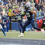 Seattle Seahawks running back Rashaad Penny (20) scores his second touchdown in the first half of an NFL football game against the Detroit Lions, Sunday, Jan. 2, 2022, in Seattle as Seahawks wide receiver Tyler Lockett (16) reacts in the background. (AP Photo/John Froschauer)