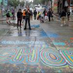 FILE - A sign on the street reads "Welcome to the CHOP" as protesters stand near barricades at the CHOP (Capitol Hill Occupied Protest) zone in Seattle on Tuesday, June 30, 2020. An investigation by the city's police watchdog shows Seattle Police exchanged detailed fake radio transmissions about a nonexistent group of menacing right-wing extremists at a crucial moment during 2020 racial justice protests. Officials said fabricating the group of Proud Boys violated department policies. (AP Photo/Ted S. Warren, File)