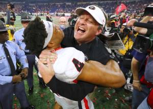 Georgia head coach Kirby Smart celebrates winning the College Football Playoff Championship game against Alabama, getting a hoist from outside linebacker Bolan Smith, early Tuesday, Jan. 11, 2022, in Indianapolis. (Curtis Compton/Atlanta Journal-Constitution via AP)