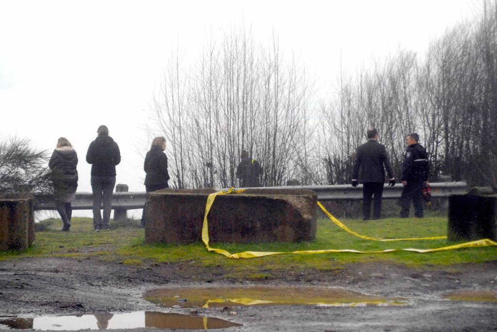 Rescuers, police and others look off a foggy bluff above where an injured person was located on the beach below on Wednesday in Port Angeles. (Keith Thorpe/Peninsula Daily News)