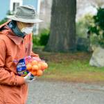 Volunteer Meso Tadeo accepted a donation of a bag of oranges from a passerby outside St. Pauls Episcopal Church last week. (Diane Urbani de la Paz/Peninsula Daily News)