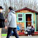 Bayside Housing & Services director Gary Keister, left, welcomes Port Townsend City Manager John Mauro to Pats Place, the new tiny home village, at Saturday afternoons blessing ceremony. (Diane Urbani de la Paz/Peninsula Daily News)