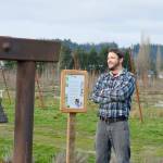 Cidermaker Andrew Byers of Finnriver Farm & Cidery, winner of the Good Food Award for its Perry pear wine, stands beside the farms Watershed Bell, cast by the late Tom Jay. (Diane Urbani de la Paz/Peninsula Daily News)
