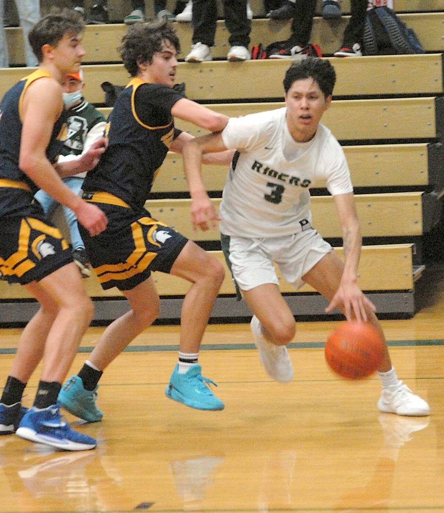 Port Angeles Quanah Wheeler, right, squeezes past Bainbridge Islands Everett Moore, left, and Charlie Diiono Triesch on Tuesday night at Port Angeles High School. (Keith Thorpe/Peninsula Daily News)