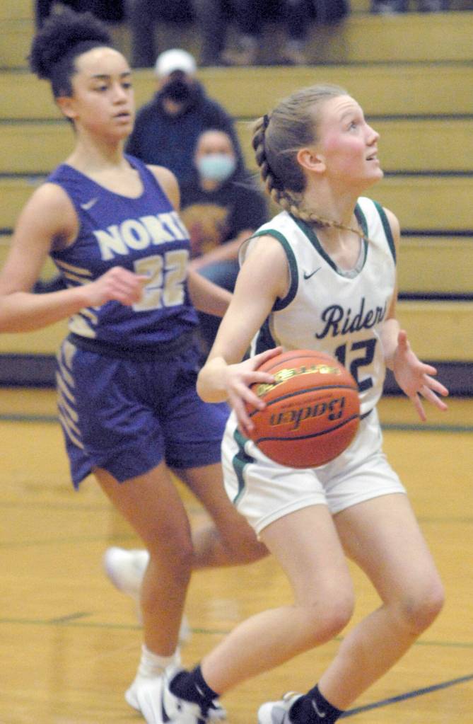 Keith Thorpe/Peninsula Daily News Port Angeles Isabelle Felton, right, sets her sights on the hoop while chased by North Kitsaps Ayanna Selembo on Thursday in Port Angeles.
