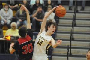 Forks' Ryan Rancourt (32 ) out-jumps Raymond's Morgan Anderson (30) to start the overtime portion of Saturday night's league game played in Forks. Forks won 67-66. (Lonnie Archibald/for Peninsula Daily News)