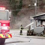 Ethan Grossell of the Port Angeles Fire Department cools hot spots left over from a fire at Castaways Restaurant Lounge early Monday morning. (Dave Logan/for Peninsula Daily News)