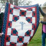 Jon and Valkyrie Ferguson hold up the Quilts of Valor quilt given to Valkyrie earlier this month. photo by Chris Bates