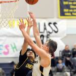 Forks senior Riley Pursley scores over Chief Leschis Brendon Brown Wednesday night in Forks where the Spartans defeated the Warriors 68 to 54. (Lonnie Archibald/for Peninsula Daily News)