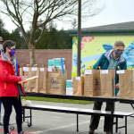 Local 20/20 volunteers  from left, Margaret Backer of Port Hadlock, Elizabeth Bindschadler of Quilcene and Deborah Stinson of Port Townsend  hand out thousands of free N95 masks on Saturday at Port Townsends Blue Heron Middle School. The effort was organized by NPREP, Local 20/20s countywide neighborhood preparedness action group. (Diane Urbani de la Paz/Peninsula Daily News)
