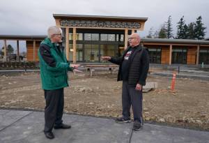 W. Ron Allen, right, chairman of the Jamestown S'Klallam Tribe, talks with Brent Simcosky, left, tribal health director, Wednesday, Feb. 2, 2022, in front of the Jamestown Healing Clinic, in Sequim, Wash. The tribe is building a full-service health center to treat both tribal members and other community residents for opioid addictions. Earlier in the week, Native American tribes across the U.S. settled a lawsuit against drug maker Johnson & Johnson and the largest three drug distribution companies in the U.S. for $590 million. The money won't be distributed quickly, but tribal leaders say it will play a part in healing their communities from an epidemic that has disproportionately killed Native Americans. (AP Photo/Ted S. Warren)