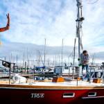 On Mondays sun-drenched skies, Ben Doerr of Bainbridge Island directs a crane operator while Port Townsend rigger Sean Ranking, from Northwest Sails and Canvas, guides the mast into Doerrs 44-foot Pierson Countess motor sailer. Doerr did a refit on his charter boat, True, including updates and wiring. (Steve Mullensky/for Peninsula Daily News)