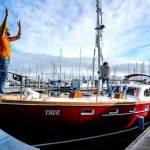 On Mondays sun-drenched skies, Ben Doerr of Bainbridge Island directs a crane operator while Port Townsend rigger Sean Ranking, from Northwest Sails and Canvas, guides the mast into Doerrs 44-foot Pierson Countess motor sailer. Doerr did a refit on his charter boat, True, including updates and wiring. (Steve Mullensky/for Peninsula Daily News)