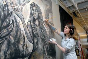 Keith Thorpe/Peninsula Daily News
Ashley Morgan works on a yet-unnamed mural outside the One of a Kind Gallery at The Wharf in Port Angeles on Thursday. She'll also appear this weekend during the gallery' pop-up art market.