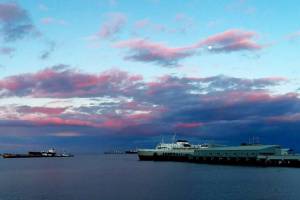 The Coho ferry arrives in Port Angeles from Victoria on Monday afternoon as the sun sets and the moon rises. The Canadian government announced the following day that, starting Feb. 28, travelers have the option of using a COVID-19 rapid antigen test rather than a PCR test, so long as it is administered by a health care professional. Also, on arrival in Canada, testing requirements will be eased for those who are fully vaccinated against the virus. (Pierre LaBossiere/Peninsula Daily News)