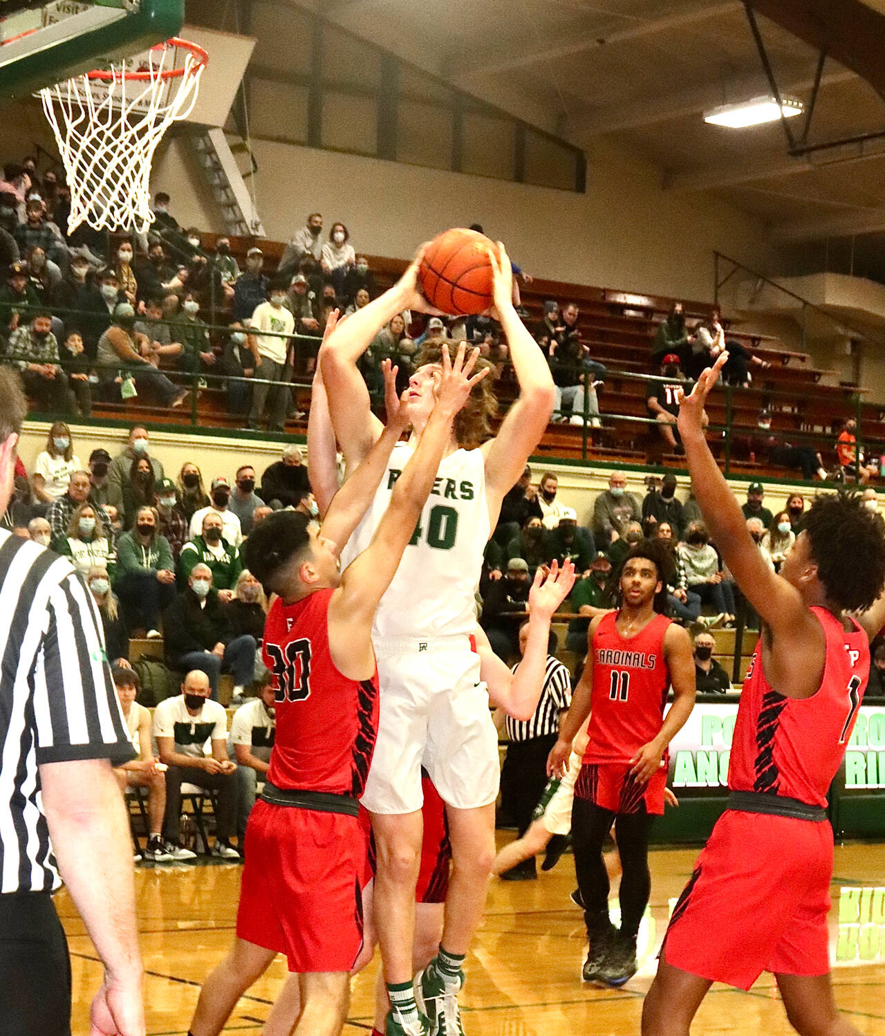 Port Angeles John Vaara soars over Franklin Pierces Brandon Herrera during the Roughriders 68-51 Class 2A District 2/3 tournament victory Wednesday. (Dave Logan/for Peninsula Daily News)