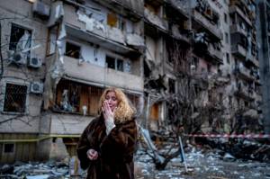Natali Sevriukova reacts next to her house following a rocket attack the city of Kyiv, Ukraine, Friday, Feb. 25, 2022. (AP Photo/Emilio Morenatti)