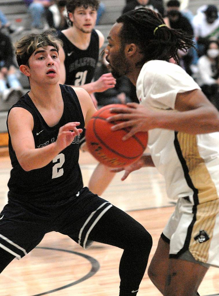 Peninsulas Rayshawn Harris, right, goes face to face with Bellevues Maui Sze on Saturday at Peninsula College. (Keith Thorpe/Peninsula Daily News)