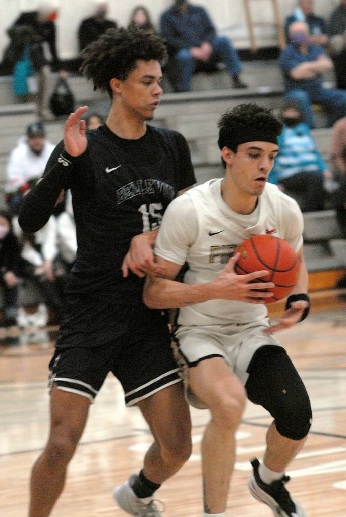 Keith Thorpe/Peninsula Daily News Peninsulas KeAndre Hunter-Holiday hangs on to the ball as Bellevues Nate Johnson defends on Saturday in Port Angeles.