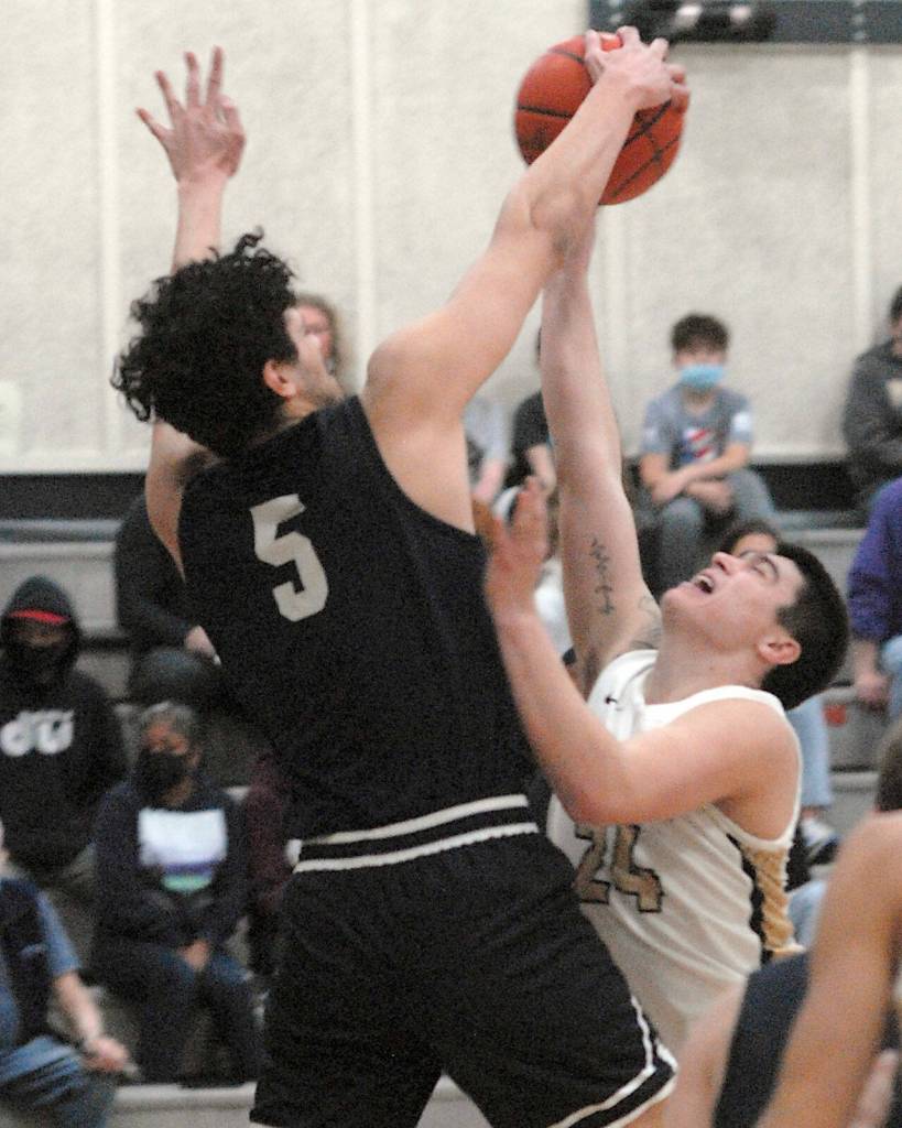 Keith Thorpe/Peninsula Daily News Peninsulas Isaac Garcia, right, is denied the shot by Bellevues Bishop Tosi on Saturday at Peninsula College.