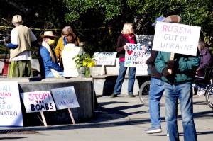 About 25 people gathered at Haller Fountain in Port Townsend on Sunday afternoon to call for peace in Ukraine, Russia and the world. Holding signs and the Ukrainian flag colors, they chanted, Peace and harmony for the world and ourselves. (Phil Lusk/For Peninsula Daily News)