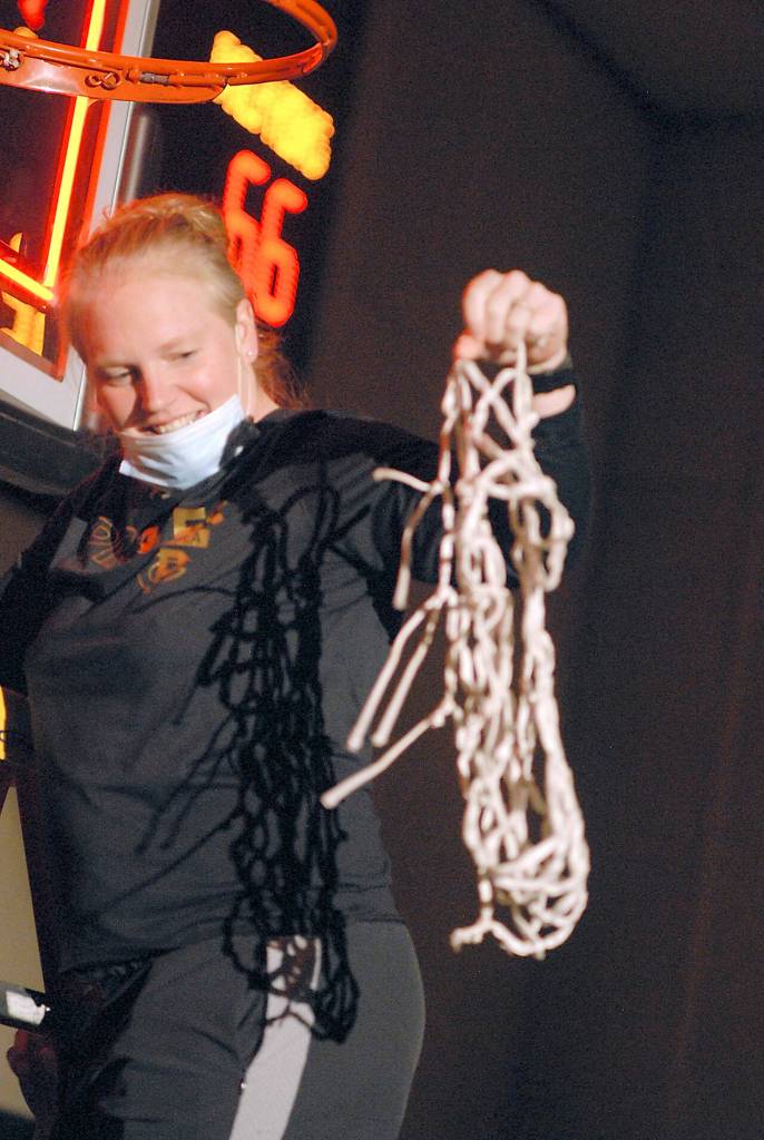 Peninsula womens head coach Alison Crumb holds the net after cutting it from the hoop in celebration of Wednesdays capture of the NWAC North Division title with a win over Shoreline. (Keith Thorpe/Peninsula Daily News)