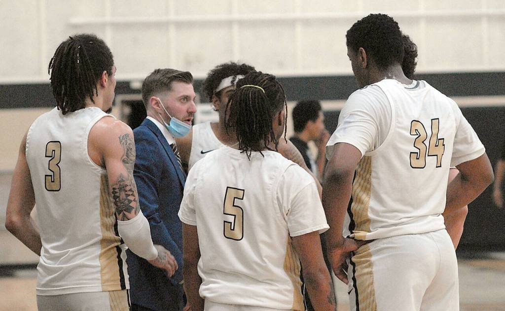 Peninsula mens head coach Donald Rollman, second from left, talks with his team during a time out on Wednesday night in Port Angeles. (Keith Thorpe/Peninsula Daily News)