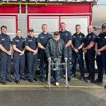 Clallam County Fire District 3 firefighters meet with Gregg Vella weeks after rescuing him from a house fire. Pictured from, left, are firefighter/EMT Jaisal White; firefighter/paramedic Len Horst; Capt. Stef Anderson; firefighter/paramedic Chase Laubach; Capt. Kjel Skov; Vella; firefighter/paramedic Mark Mullvain; Capt. Joel McKeen; firefighter/EMT Jared Romberg; firefighter/paramedic Casey Sires; firefighter/paramedic Jack Hueter. (Matthew Nash/Olympic Peninsula News Group)