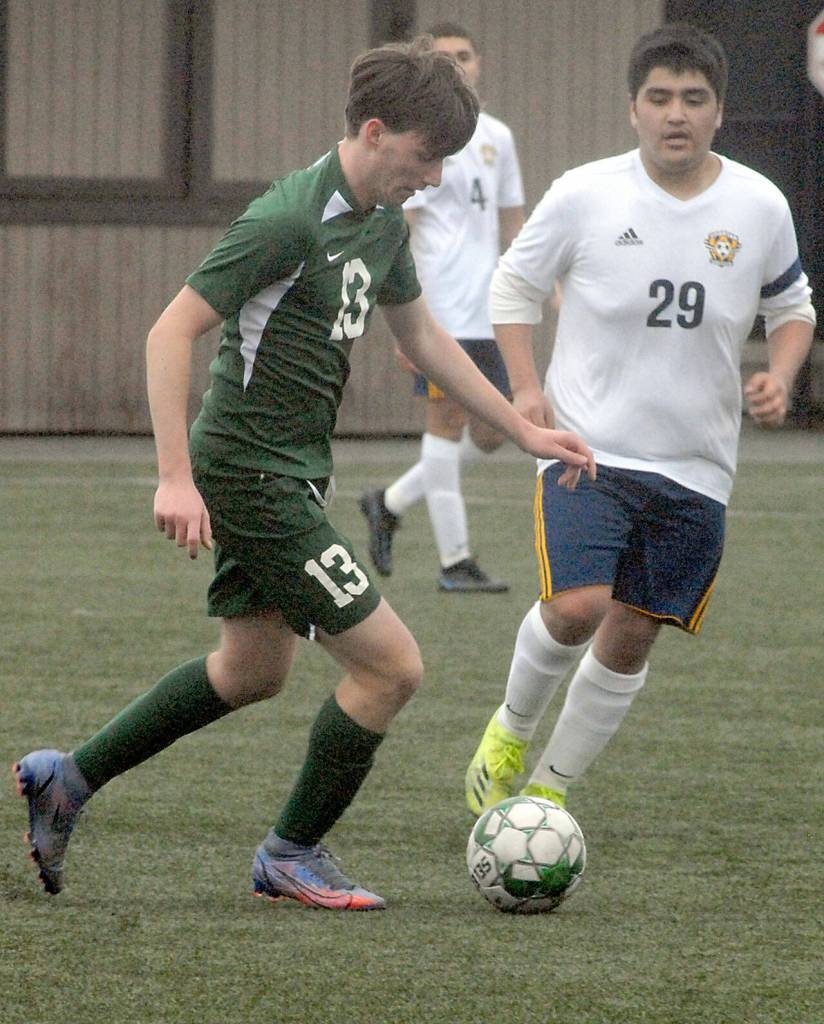 Port Angeles Caden White, left, dribbles the ball as Forks Hector Dominguez looks on during Saturdays match in Port Angeles. (Keith Thorpe/Peninsula Daily News)
